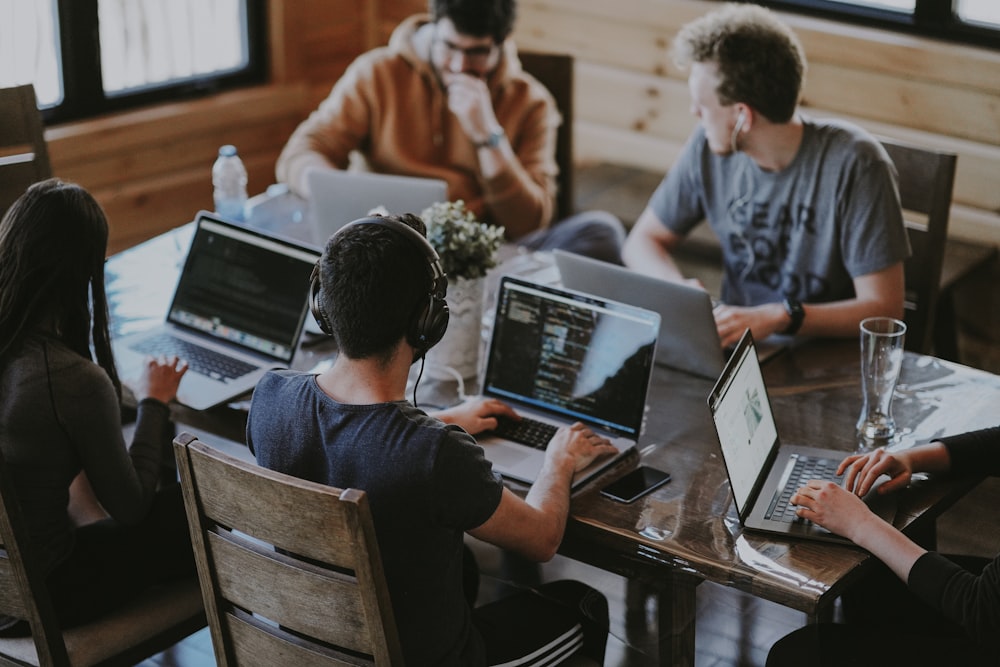 Marketing team working together around a table with laptops and notes